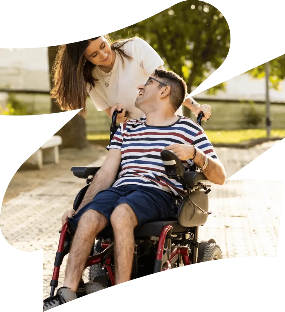 A disabled man sitting in his wheelchair and his support worker