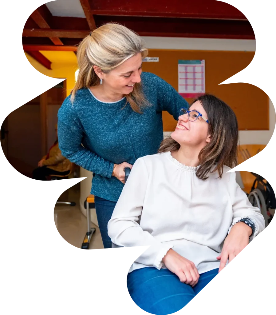 A disabled woman sitting in her wheelchair and her support worker